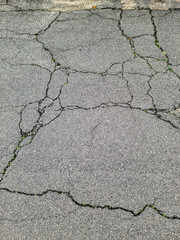 Asphalt surfaces of different streets and roads with cracks in close up