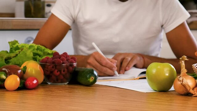 The nutritionist writes a diet nutrition plan. Selective focus.