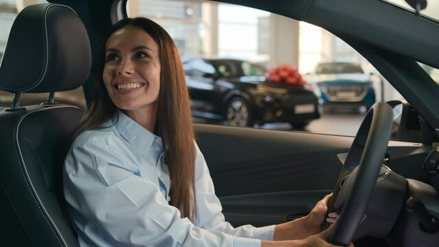 Happy Caucasian successful businesswoman joyful woman sit in new car in automobile shop rent service dealership decide choose renting buying auto purchase luxury modern buy vehicle female test drive