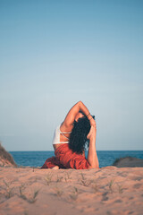 Young woman doing yoga pose on the beach
