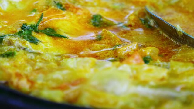 A close-up view of traditional Bahian moqueca, simmering in a rich blend of coconut milk and palm oil, showcasing the authentic flavors of Bahia, Brazil. 
