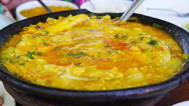 Traditional Bahian moqueca, simmering in a rich blend of coconut milk and palm oil, showcasing the authentic flavors of Bahia, Brazil. 