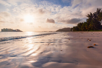 Coastal view with wet sand under sunset sky. Cote D'Or Beach landscape