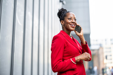 Portrait of smiling mature businesswoman using mobile phone in urban setting
