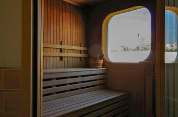 Finnish or dry sauna with oceanview or view of the sea inside male locker room of spa or wellness...