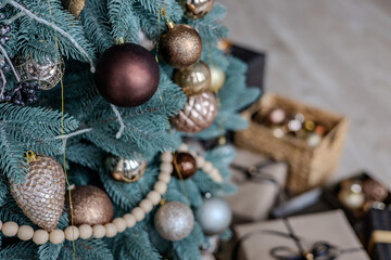 A variety of colored Christmas gifts stand near a decorative Christmas tree in the house on the...
