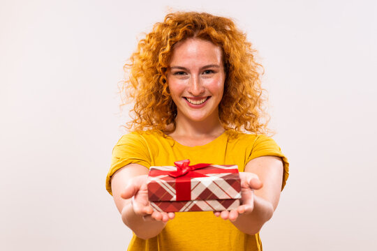 Image of beautiful happy ginger woman holding gift box.