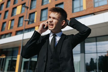 Against the backdrop of towering buildings, a nervous and stressed young adult in a business suit engages in a conversation, reflecting the pressures of the modern urban life.