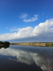 A body of water with clouds in the sky