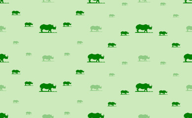 Seamless pattern of large and small green wild rhino symbols. The elements are arranged in a wavy. Vector illustration on light green background