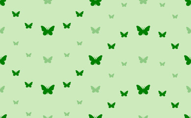 Fototapeta premium Seamless pattern of large and small green butterfly symbols. The elements are arranged in a wavy. Vector illustration on light green background