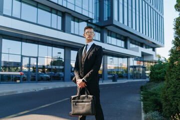 In a bustling business district, a well dressed young Caucasian American businessman in a well fitted suit stands tall, representing success and ambition.