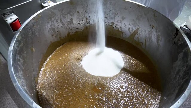 The baker adds sugar, spices and additives to the flour with sourdough in the dough mixer. The cook prepares the dough for baking bread. Kneading dough at the bakery.