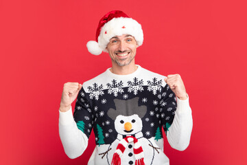 Man in holiday sweater and Santa hat on studio background. Christmas sale or special winter offer.
