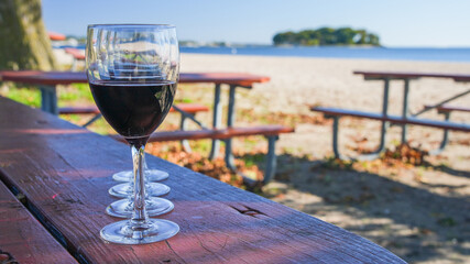 Red wine on beach table in beautiful sunny day with copy space on right side