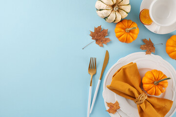 Establish a Thanksgiving table that stands out. Top view photo of plates, cutlery, pumpkins,...