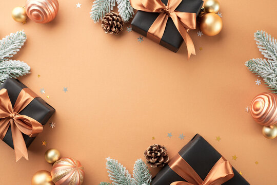The race to find and buy gifts quickly. Top view photo of present boxes, festive balls, frosty fir twigs, stars confetti, cones on terracotta background with promo zone
