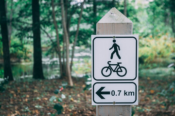 Pedestrian and bicycle road sign in the park. Road signs on a wooden pole. 