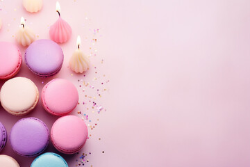 Fototapeta na wymiar New Year's Eve composition. Festive macarons, multi - colored candles, metallic fringes on pastel pink paper. Flat lay, top view. Copy space. Banner backdrop