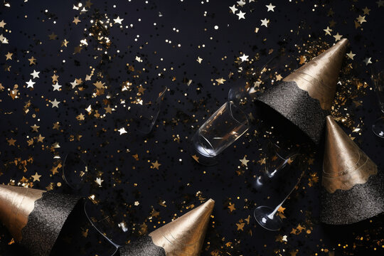 New Year's Eve Composition. Party Hats, Silver Confetti, Champagne Flutes On A Twilight - Hued Silk Surface. Flat Lay, Top View. Copy Space. Banner Backdrop