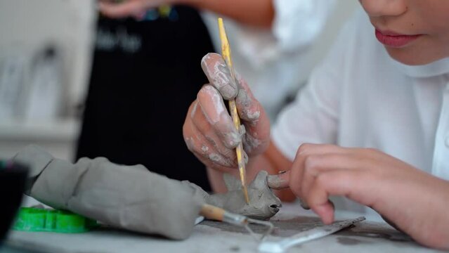Teen Boy At Art School Clay Sculpt in Art Class. Middle school kid learning how to create with help of teacher