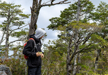 A young man enjoys a sandwich, savoring his reward upon reaching the mountain peak.