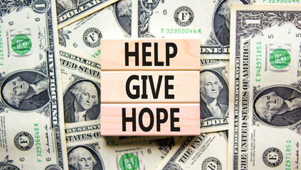 Help give hope symbol. Concept word Help give hope on beautiful wooden block. Dollar bills....