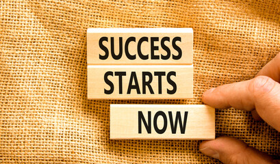 Success starts now symbol. Concept word Success starts now on beautiful wooden block. Businessman hand. Beautiful canvas table background. Business motivational success starts now concept. Copy space.