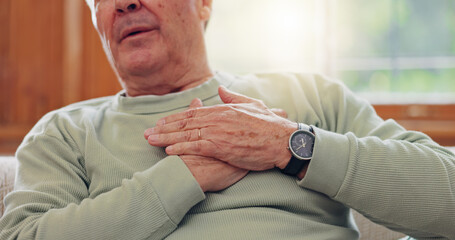 Hands, heart attack or condition with a senior man in pain closeup in the living room of his...