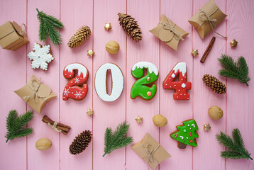 The numbers are gingerbread 2023 on a pink background. Beautiful flatlay made of natural materials and gifts. Christmas background. 