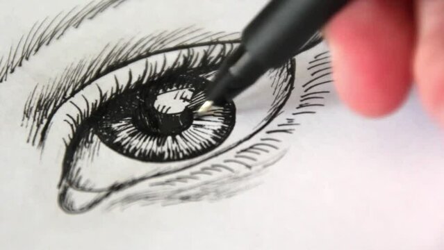 Hand draws in black pen a sketch of a female eye. Ink illustration. Video of the drawing process. Artist master class art studio. Motion footage