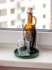 Containers for oil, vinegar and spices on the windowsill