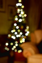Bokeh lights of Christmas tree background at home. Defocused Christmas tree lights.