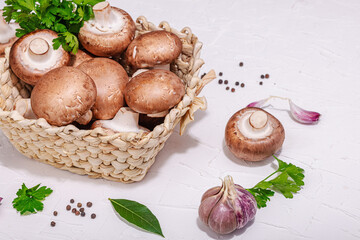 Raw brown royal champignons in the basket. Cooking vegan food concept. Garlic, greens, spices