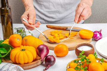 A woman is preparing a tomato salad. Ripe vegetables, herbs, aromatic spices, olive oil