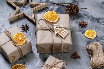 Wrapping rustic eco Christmas packages with brown paper and string on dark background