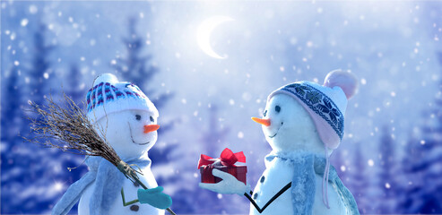 Merry Christmas and happy New Year greeting card with copy-space. Snow background. Two cheerful friends snowmen standing in winter  landscape