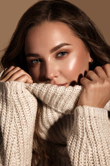 Beautiful young girl with gentle make-up in warm sweater and long straight hair. Beauty face. - obrazy, fototapety, plakaty