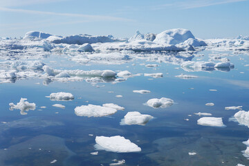 Iceberg floats in the crystal-clear water, in the summer of Greenland
