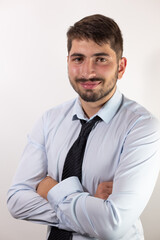 portrait d'un jeune homme de 25 ans souriant, employé de bureau ou homme d'affaires, brun avec d la barbe. Il porte une chemise et une cravate