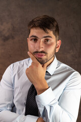 portrait d'un jeune homme de 25 ans souriant, employé de bureau ou homme d'affaires, brun avec d...