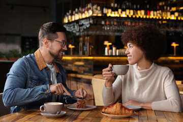 Fototapeta na wymiar International relationships. Lovely couple having romantic date in cafe