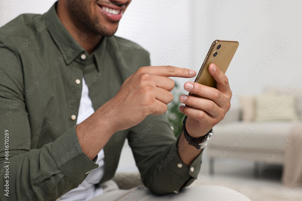Poster man sending message via smartphone indoors, closeup