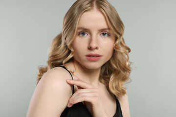 Naklejka premium Portrait of beautiful woman with blonde hair on light grey background