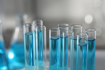 Test tubes with light blue liquid in laboratory, closeup