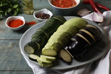 Cooking delicious ratatouille. Plate with fresh cut vegetables on light blue wooden table, closeup