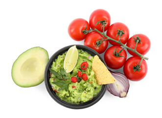Delicious guacamole with nachos chips, lime and different ingredients isolated on white, top view