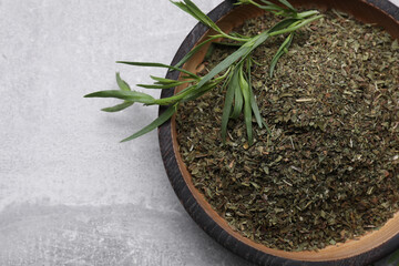 Dry and fresh tarragon on light gray textured table, top view. Space for text