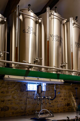 Blending process of cognac spirit and old French oak barrels in cellar in old distillery in Cognac...