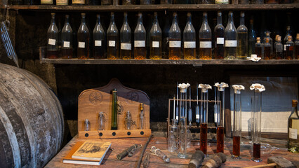 Blending process of cognac spirit and old French oak barrels in cellar in old distillery in Cognac...